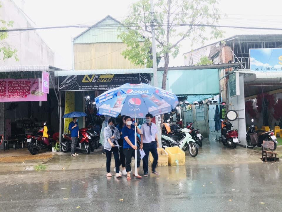 Tình nguyện viên che dù giúp thí sinh khỏi ướt