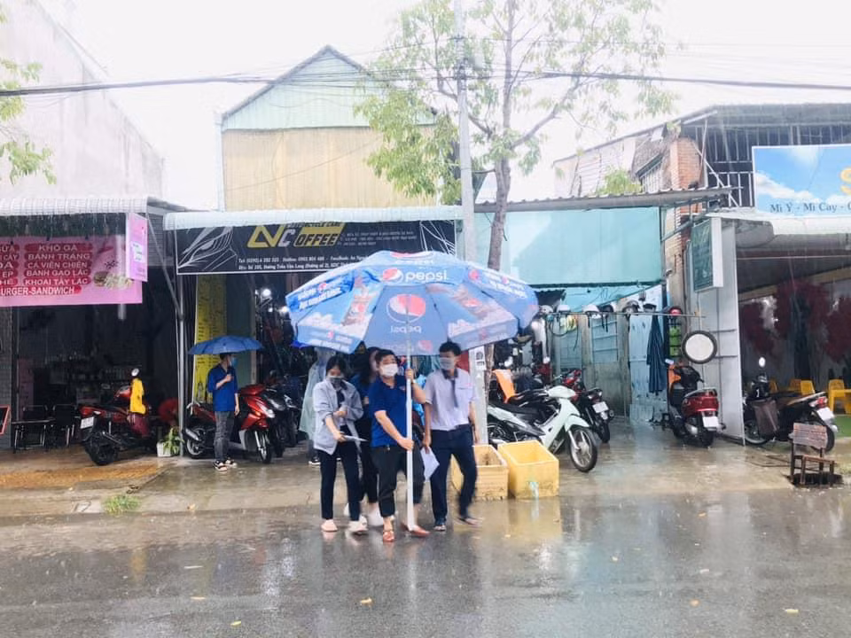Tình nguyện viên che dù giúp thí sinh khỏi ướt