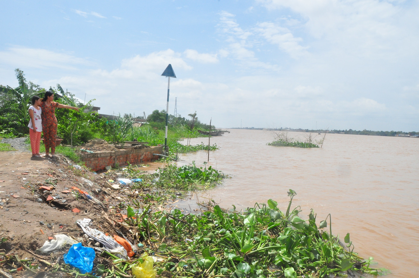 Một hộ dân ở cồn Phú Đa, huyện Chợ Lách, tỉnh Bến Tre bên căn nhà của mình bị chìm xuống sông do sạt lở vào năm 2018. Ảnh: Hòa Hội. Một hộ dân ở cồn Phú Đa, huyện Chợ Lách, tỉnh Bến Tre bên căn nhà của mình bị chìm xuống sông do sạt lở vào năm 2018. Ảnh: Hòa Hội.