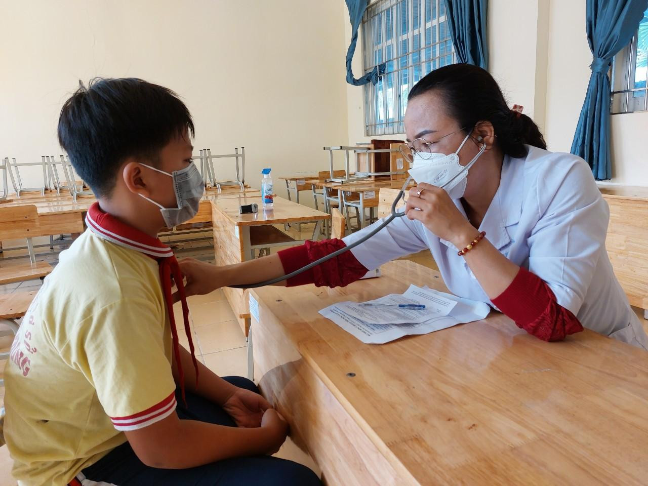 Trẻ em được khám sàng lọc trước khi tiêm vắc xin Trẻ em được khám sàng lọc trước khi tiêm vắc xin