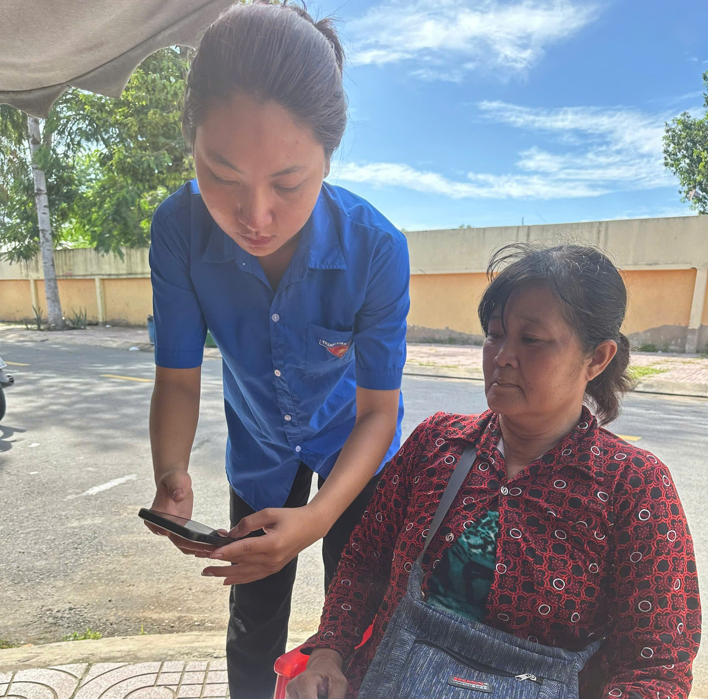 Đoàn viên thanh niên hỗ trợ người dân cài đặt ứng dụng chuyển đổi số.