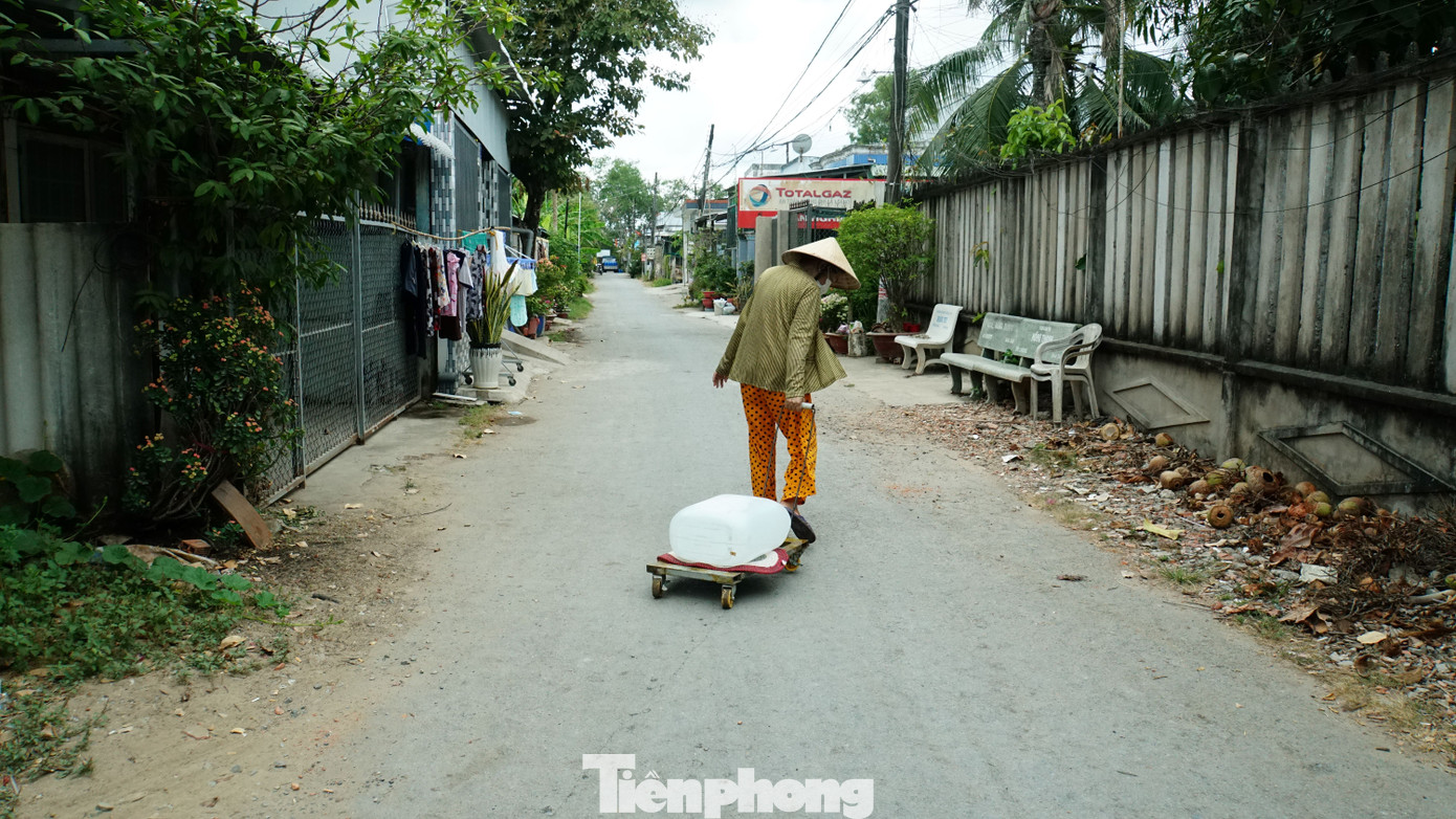 Cụ già kéo từng can nước mang về nhà sinh hoạt tại xã An Hóa, huyện Châu Thành, tỉnh Bến Tre. Ảnh: Hòa Hội