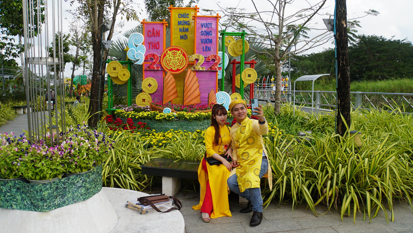 Hai bạn trẻ háo hức chụp ảnh trong vườn hoa xuân Cần Thơ 2022. - Ảnh: Hòa Hội