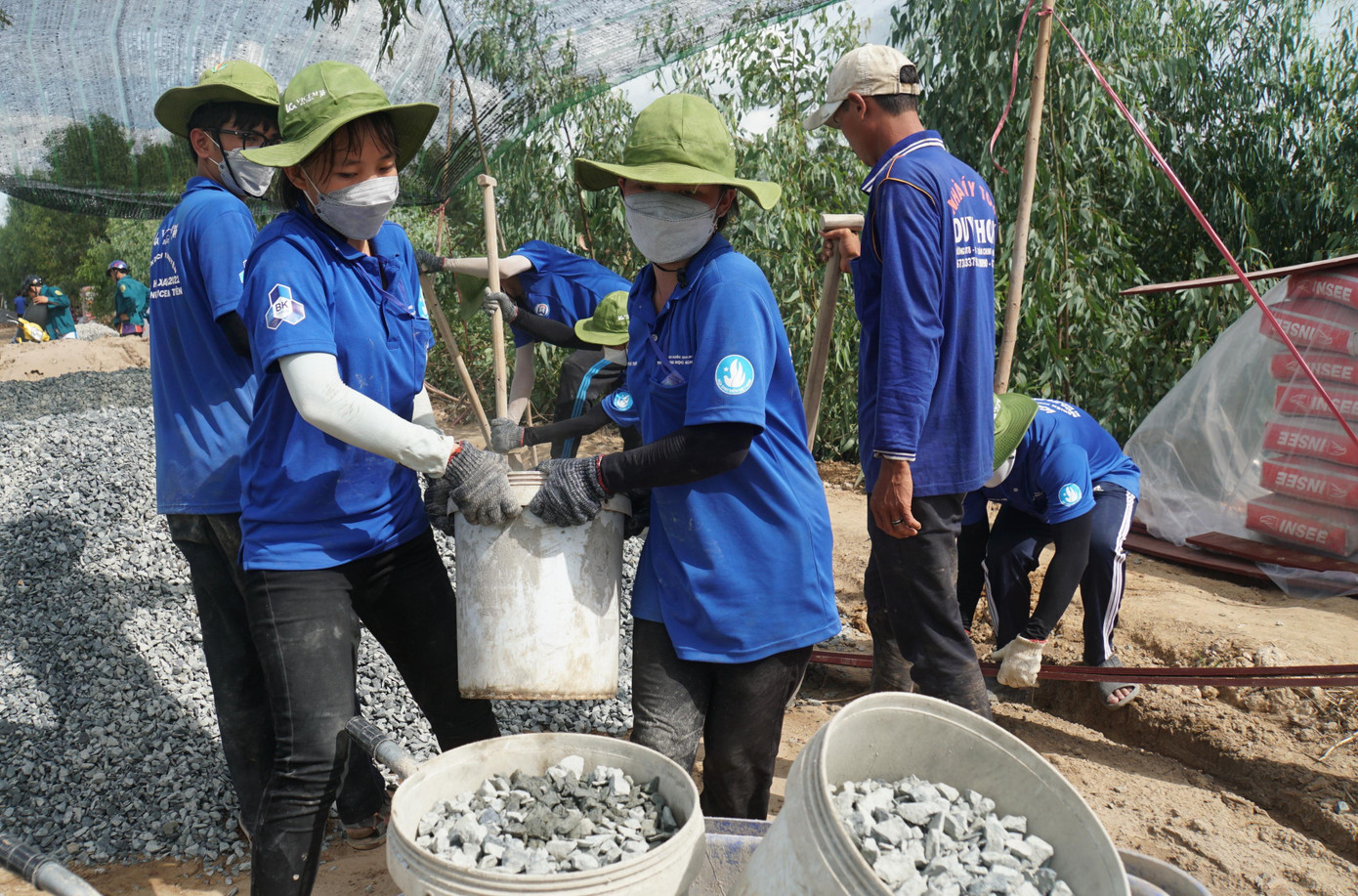 Các cô gái nhiệt tình khuân đá làm lộ nông thôn. - Ảnh: Hòa Hội