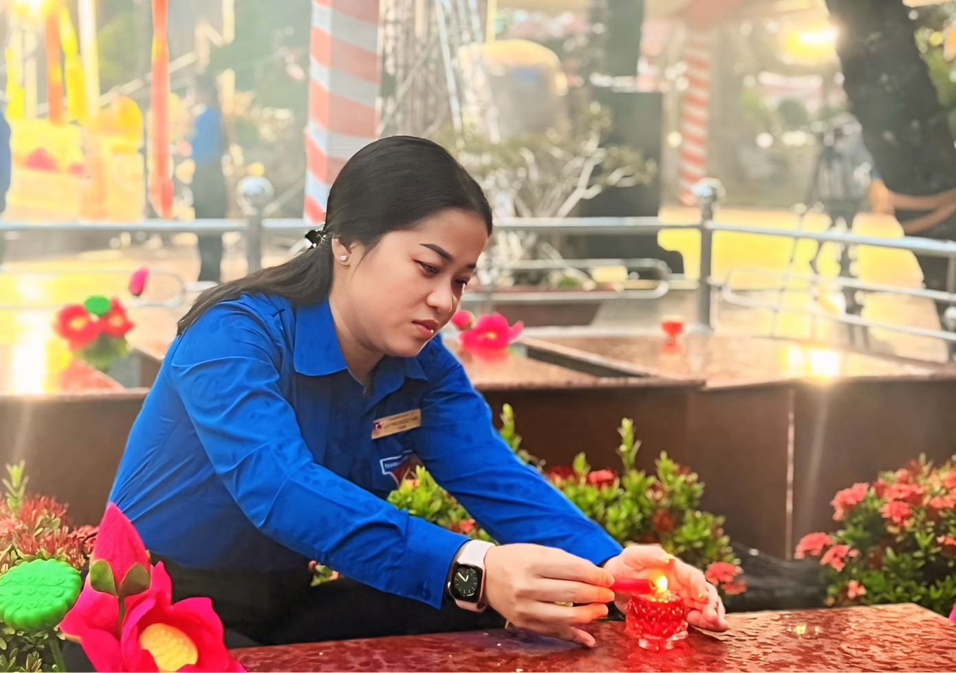 Chị Lư Thị Ngọc Anh - Bí thư Thành Đoàn Cần Thơ thắp nến tại mộ liệt sĩ. Ảnh: TĐCT