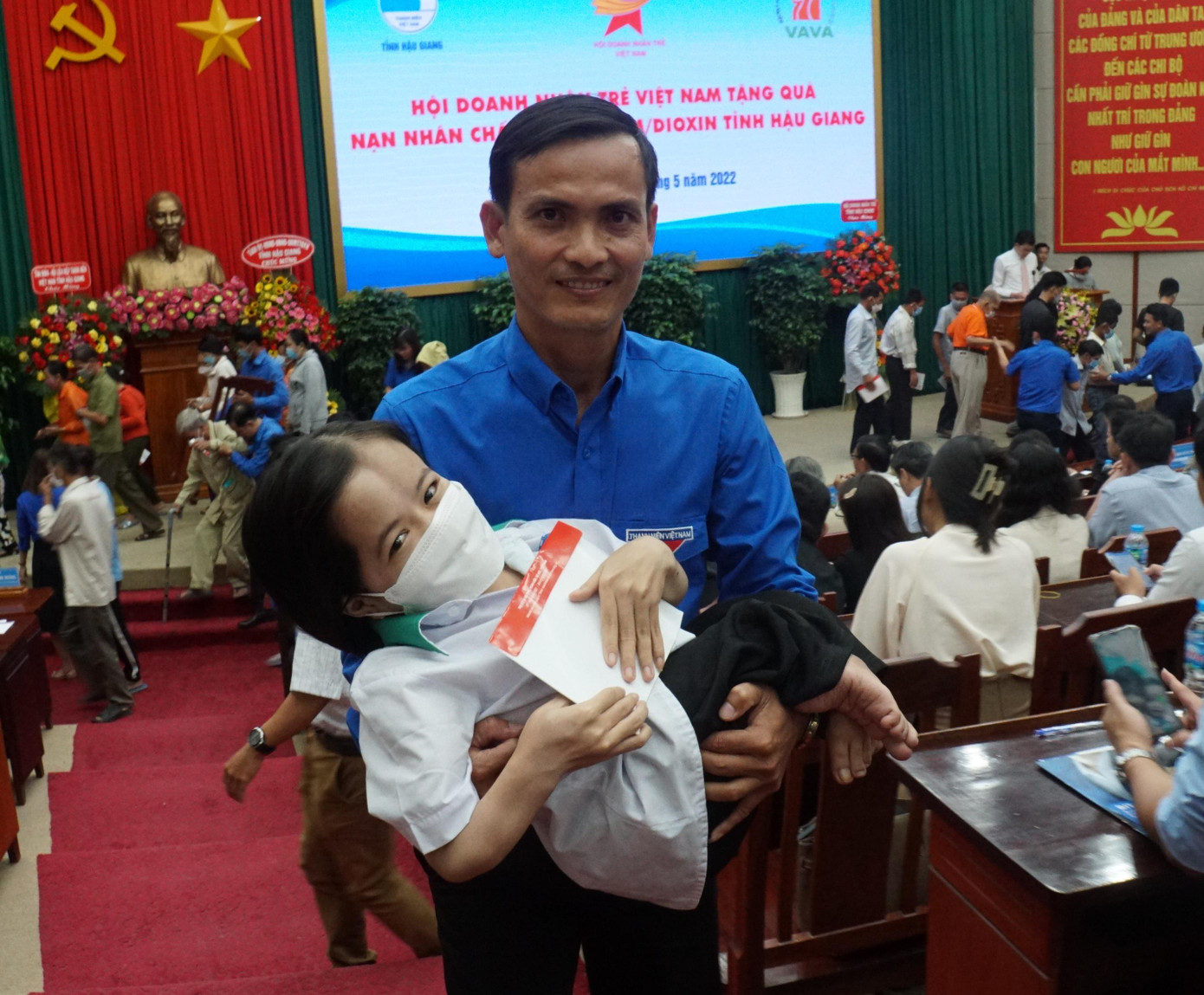 Cán bộ Đoàn hỗ trợ nạn nhân chất độc da cam nhận quà. - Ảnh: Hòa Hội