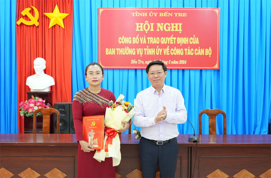 Ông Trần Thanh Lâm - Phó Bí thư Thường trực Tỉnh ủy Bến Tre, trao quyết định và tặng hoa chúc mừng bà Nguyễn Thị Mai Rý. (Ảnh: Phương Thảo)