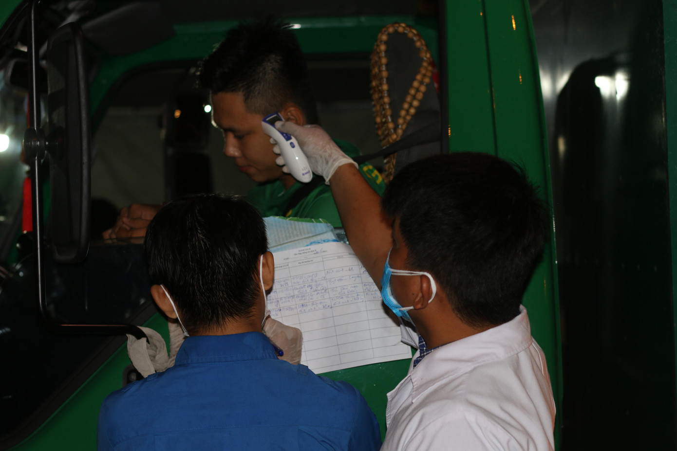 Cán bộ y tế đo thân nhiệt tài xế xe vào rạng sáng 30/5.