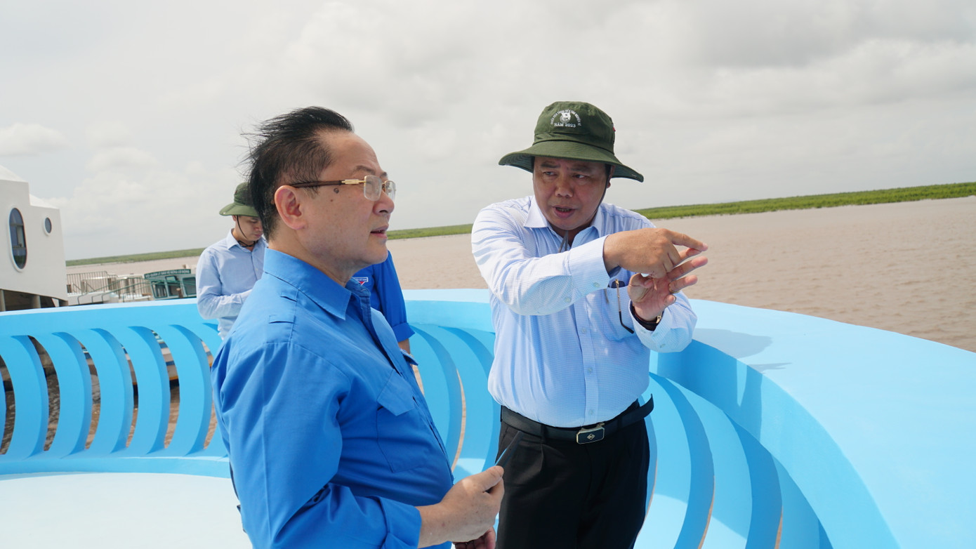 Bí thư Tỉnh ủy Cà Mau Nguyễn Tiến Hải (áo trắng) trò chuyện cùng nhà báo Lê Xuân Sơn - Tổng Biên tập báo Tiền Phong về khu vực bãi bồi đất mũi Cà Mau.