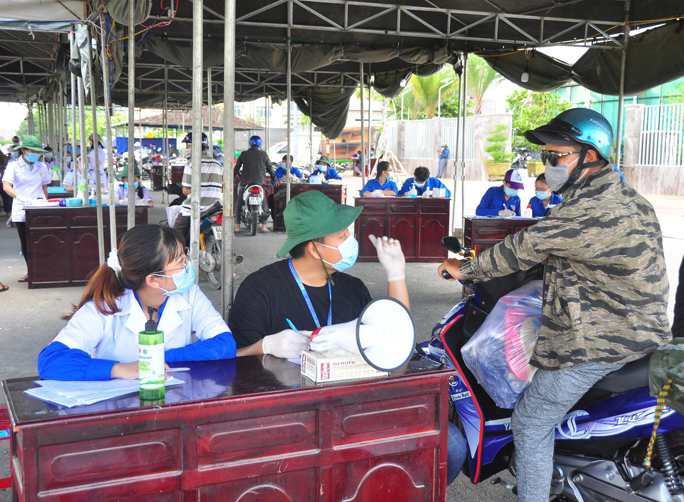 Trưa 3/6, ghi nhận của phóng viên Tiền Phong, mặc dù trời nắng như đổ lửa nhưng các cán bộ y tế, công an, tình nguyện viên ở các chốt trực trên địa bàn thành phố Cần Thơ, điển hình tại chốt Siêu thị GO, đường dẫn cầu Cần Thơ rất nhiệt tình làm công việc của mình. - Ảnh: Hòa Hội