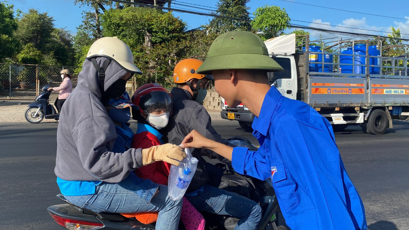 Các bạn không ngại trời nắng gay gắt để trao tặng nước suối cho bà con.