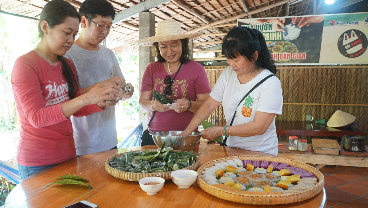 Khách trải nghiệm làm bánh dân gian tại nhà vườn Cồn Sơn. - Ảnh: Hòa Hội Khách trải nghiệm làm bánh dân gian tại nhà vườn Cồn Sơn. - Ảnh: Hòa Hội