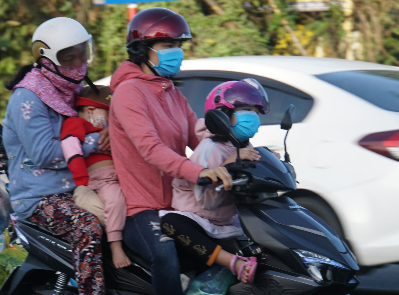 Trẻ em ngủ trong vòng tay mẹ trên xe. - Ảnh: Hòa Hội