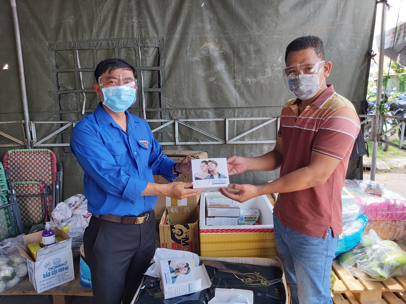 Chị Lê Thị Xuân Thảo ở quận Ninh Kiều trực tiếp cùng chồng (bên phải ảnh) mang đến chốt trao tặng gần 100 tấm kính chống giọt bắn để hỗ trợ các cán bộ, chiến sỹ làm nhiệm vụ khai báo y tế. Chị Thảo bộc bạch: &quot;Mỗi người góp một ít để cùng thành phố ngăn chặn, đẩy lùi dịch COVID-19, đem lại sự bình yên cho người dân&quot;.