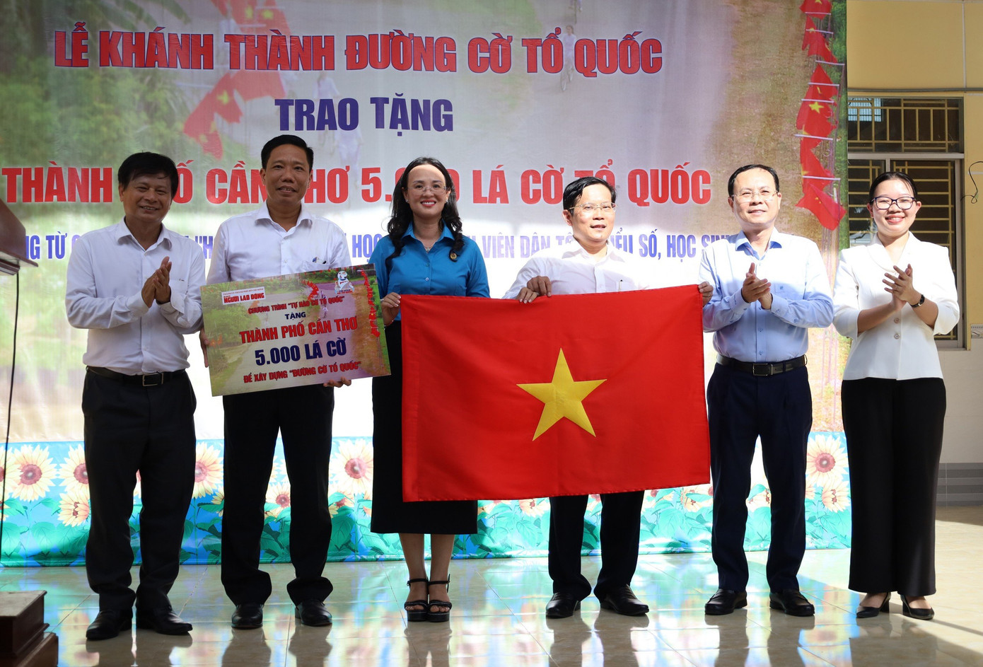 Ông Tô Đình Tuân - Tổng Biên tập Báo Người Lao Động trao lá cờ tượng trưng cho 5.000 lá cờ từ hợp phần Đường cờ Tổ quốc cho lãnh đạo TP Cần Thơ.