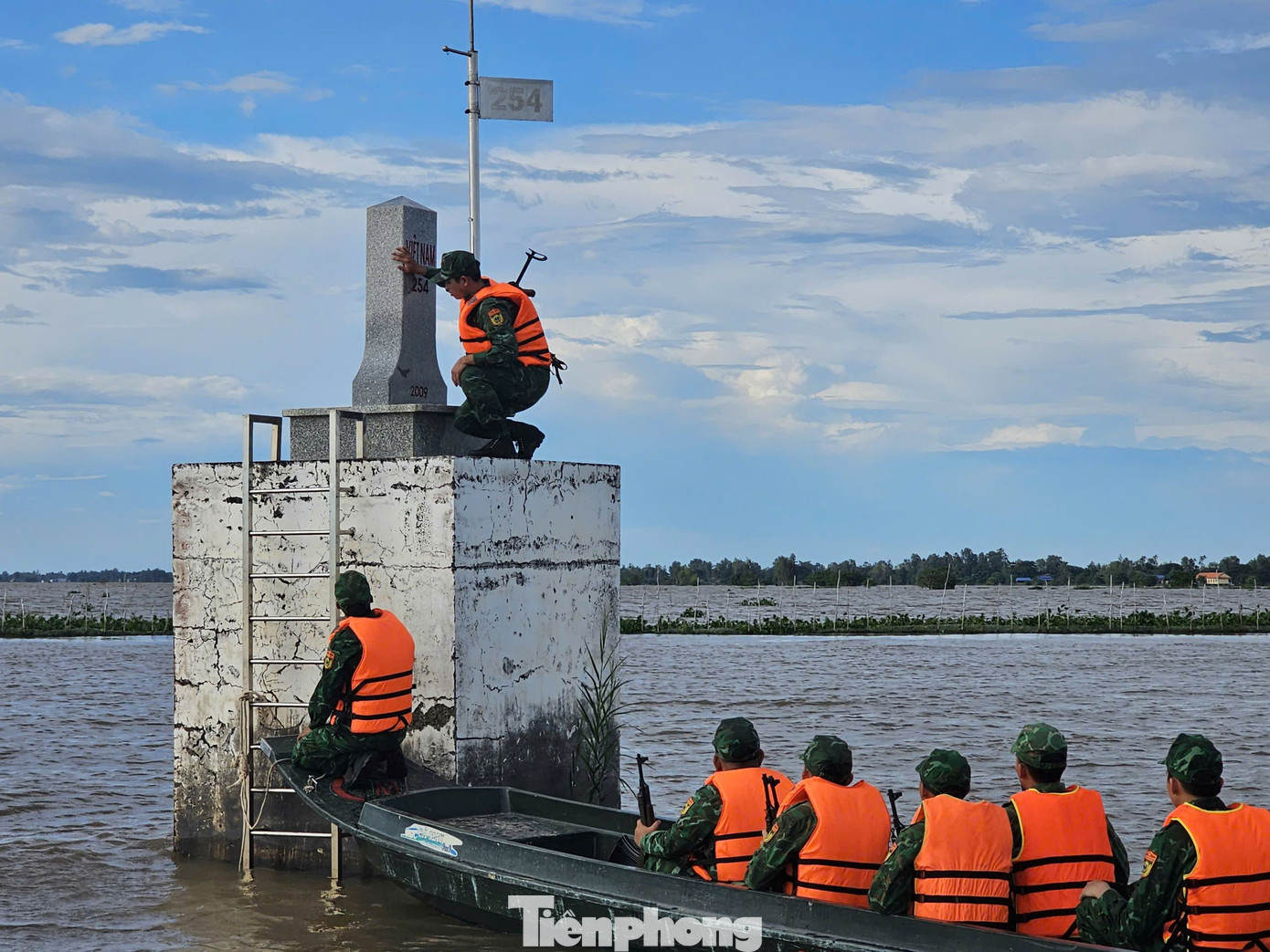 Chiến sĩ Đồn Biên phòng Nhơn Hội kiểm tra cột mốc 254 nằm giữa đồng nước. Ảnh: Hòa Hội