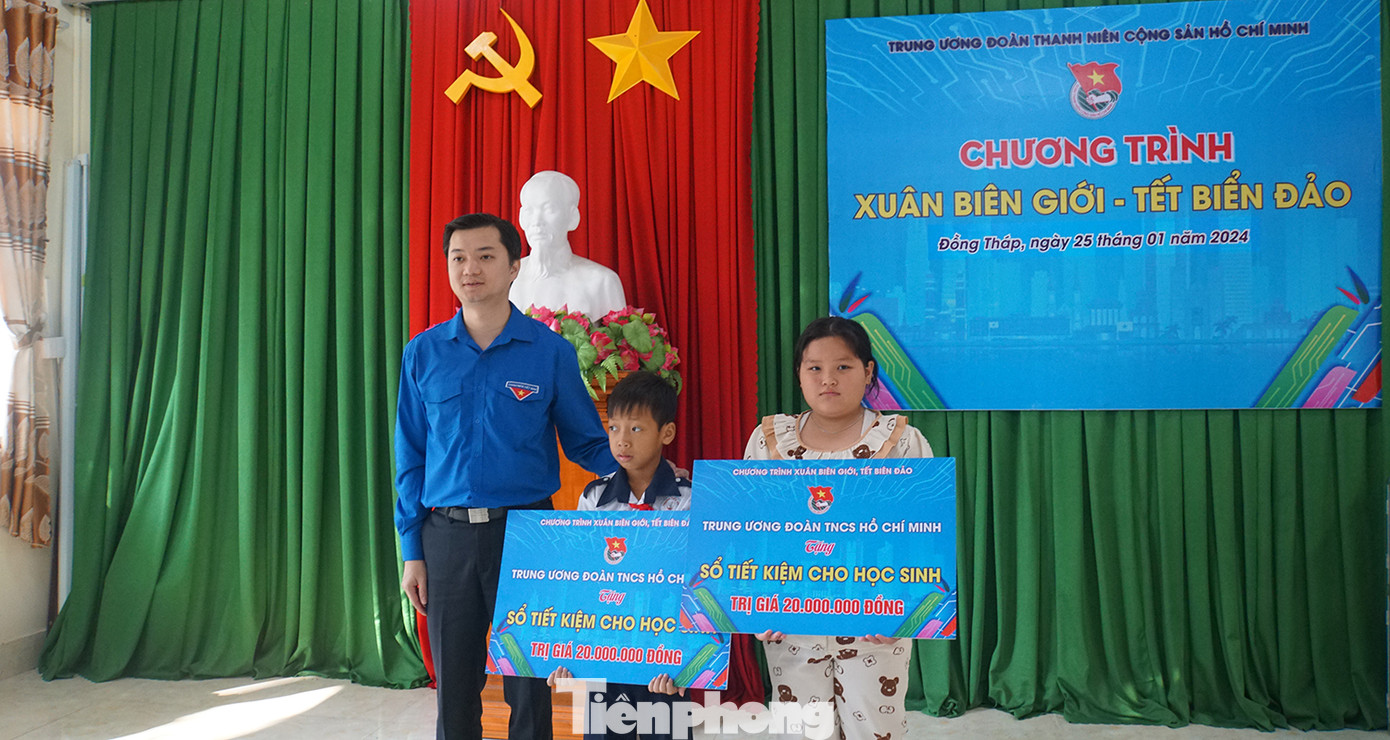 Bí thư Trung ương Đoàn Nguyễn Minh Triết tặng sổ tiết kiệm cho 2 em học sinh có hoàn cảnh khó khăn, vượt khó học giỏi, mỗi sổ trị giá 20 triệu đồng. Ảnh: Hòa Hội