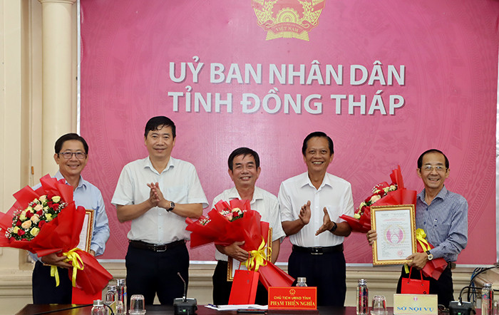 Chủ tịch UBND tỉnh Đồng Tháp Phạm Thiện Nghĩa (thứ hai từ trái sang) trao quyết định nghỉ hưu cho ông Nguyễn Thành Giang, Nguyễn Văn Phú và Trần Thanh Liêm. Ảnh: V. Tiến