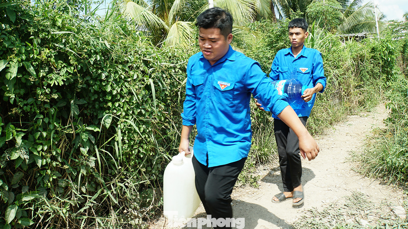 Các bạn trẻ mang nước trực tiếp đến tận nhà giúp dân. Ảnh: Hòa Hội