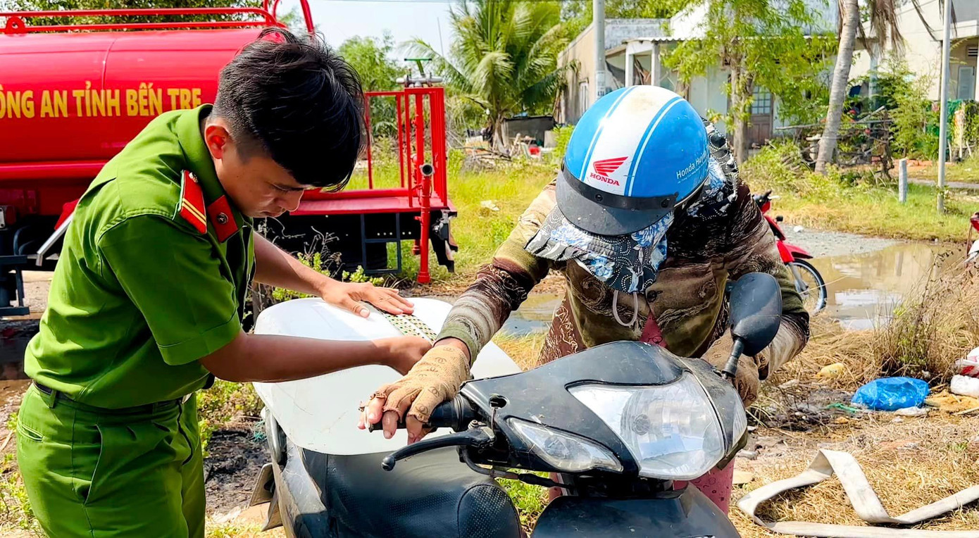Chiến sĩ công an Bến Tre hỗ trợ người dân chở nước về sinh hoạt.