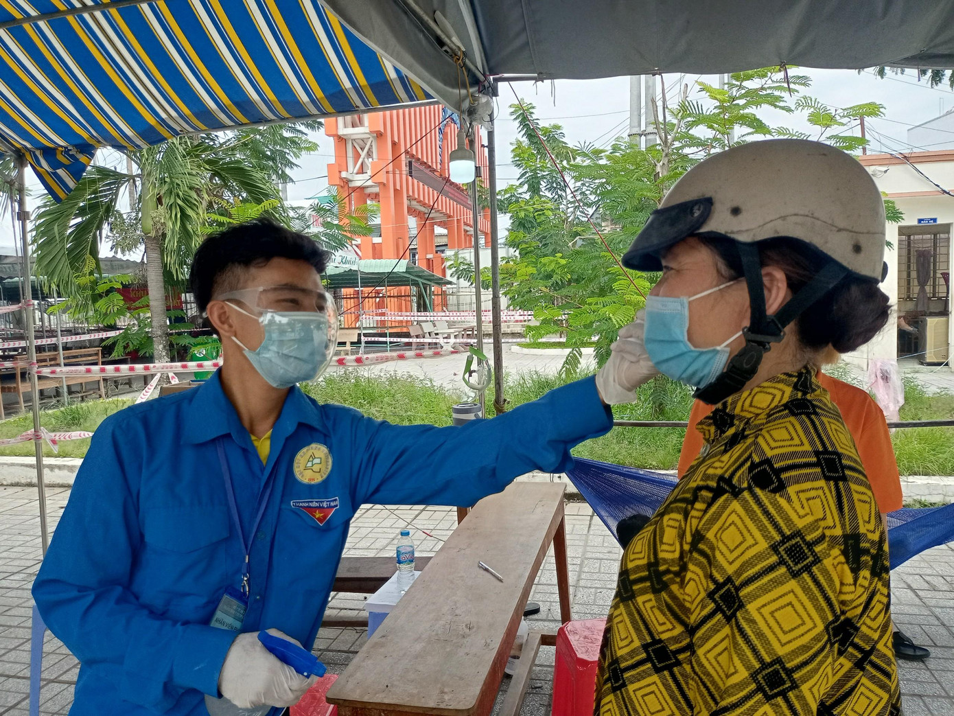 Bạn Văn Liến, sinh viên trường ĐH An Giang đo thân nhiệt cho người dân