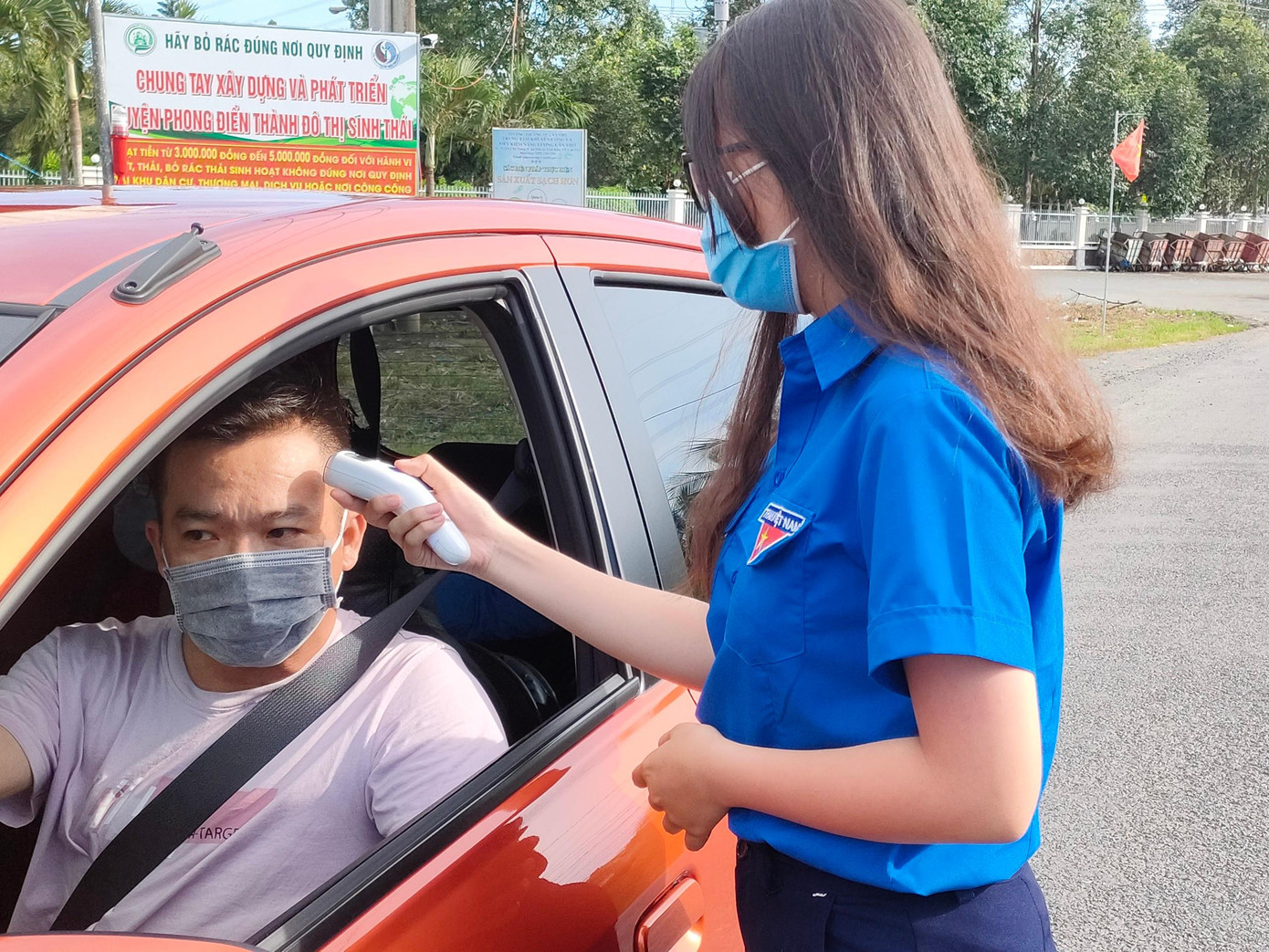 Nữ tình nguyện viên làm nhiệm vụ đo thân nhiệt