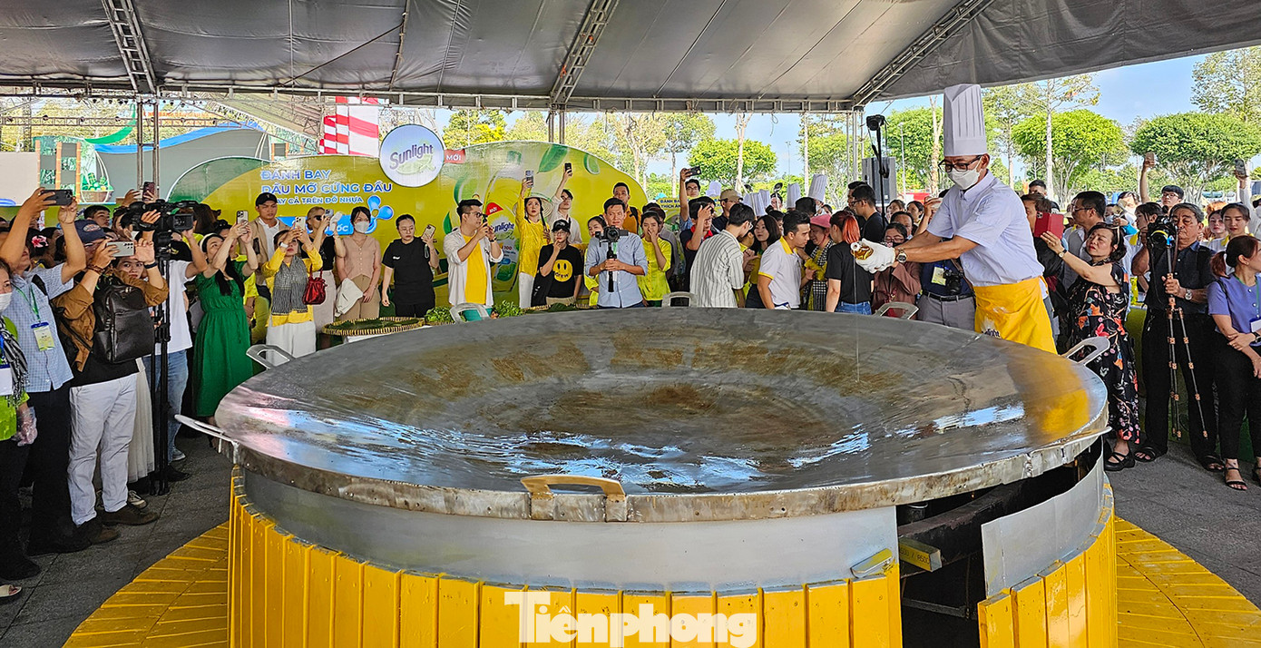 Từ 9h sáng 18/4, tại Quảng trường quận Bình Thủy (Cần Thơ), nhiều người dân đã tụ tập tại khu vực trưng bày bánh truyền thống để xem màn trình diễn làm bánh xèo đường kính 3 m. Việc tạo nên chiếc bánh xèo “siêu to khổng lồ” là hoạt động đặc biệt, thu hút nhiều sự chú ý ở Lễ hội Bánh dân gian Nam Bộ năm nay. Ảnh: Hòa Hội.