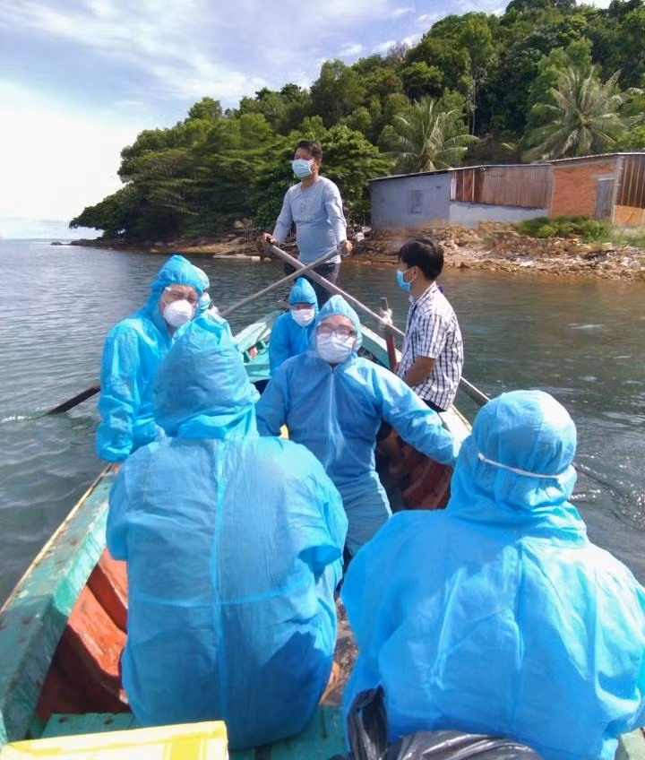 Nguyễn Thanh Nhựt (ngồi giữa đeo kính) cùng đội ngồi thuyền sang các đảo lấy mẫu cộng đồng. - Ảnh: NVCC