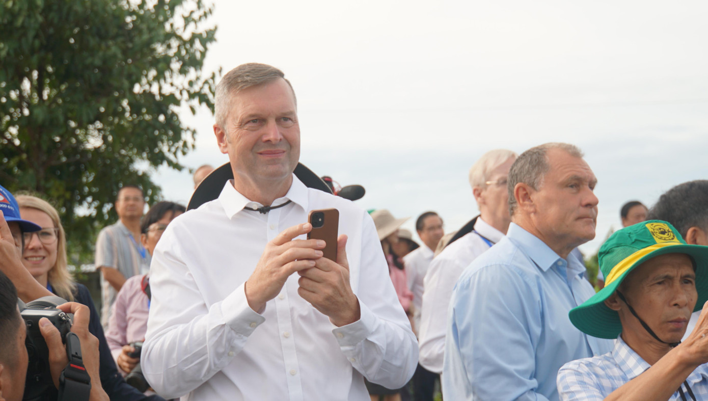 Khách quốc tế dõi theo máy bay không người lái phun thuốc trên đồng. Ảnh: Hòa Hội