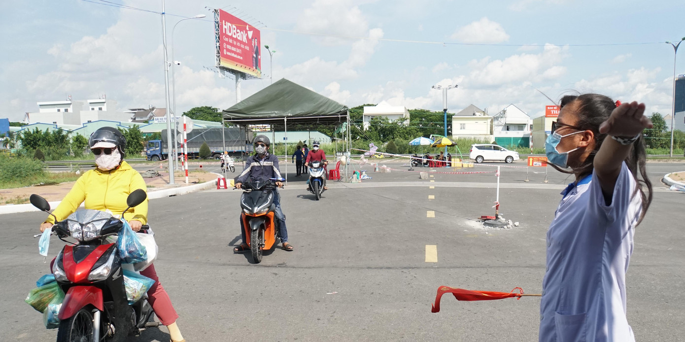 Nữ sinh ngành y đội nắng điều tiết các phương tiện vào vị trí khai báo y tế. - Ảnh: Hòa Hội