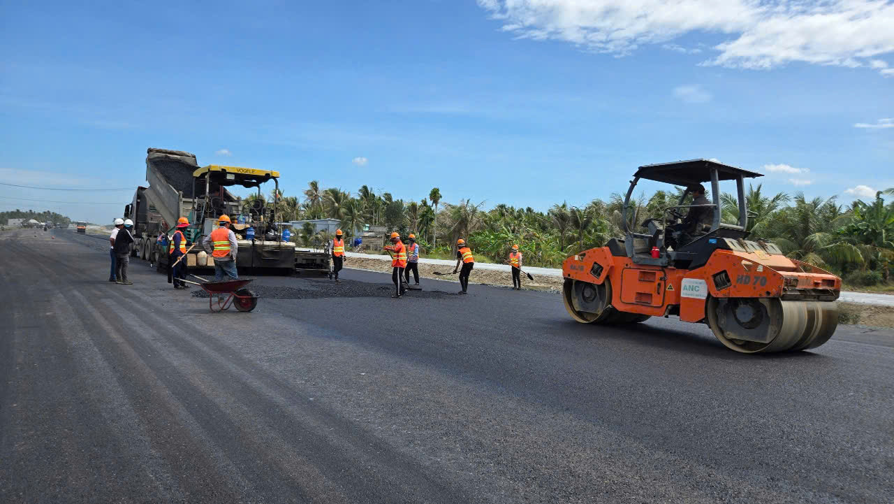 Công nhân thảm mặt đường trên đường dẫn vào cầu. Công nhân thảm mặt đường trên đường dẫn vào cầu.