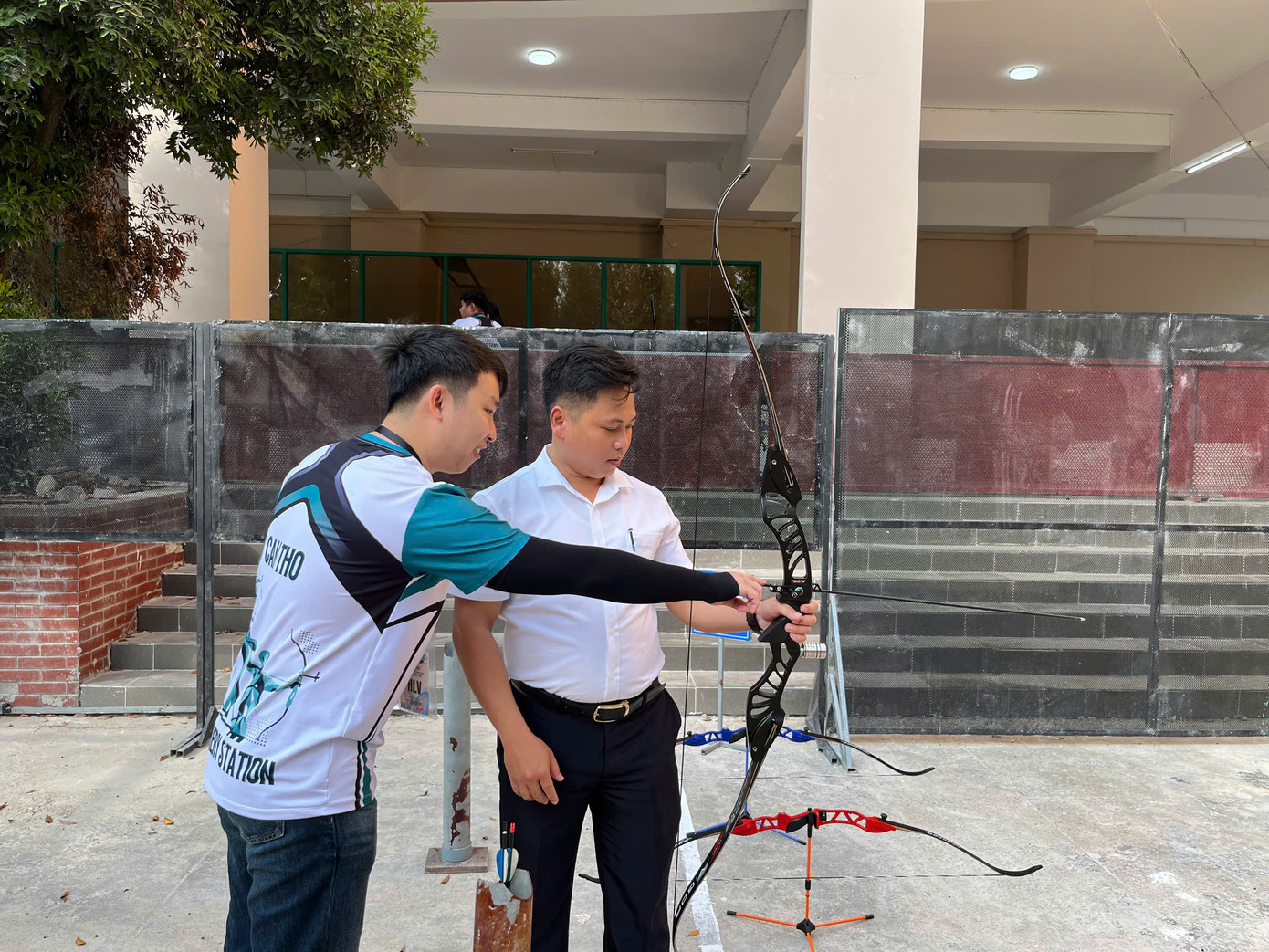 Huấn luyện viên hướng dẫn bắn cung.