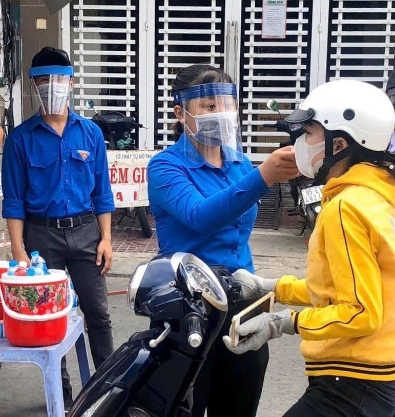ĐVTN đo nhiệt độ cho người dân tại chốt kiểm soát. - Ảnh: TĐ Ngã Bảy ĐVTN đo nhiệt độ cho người dân tại chốt kiểm soát. - Ảnh: TĐ Ngã Bảy