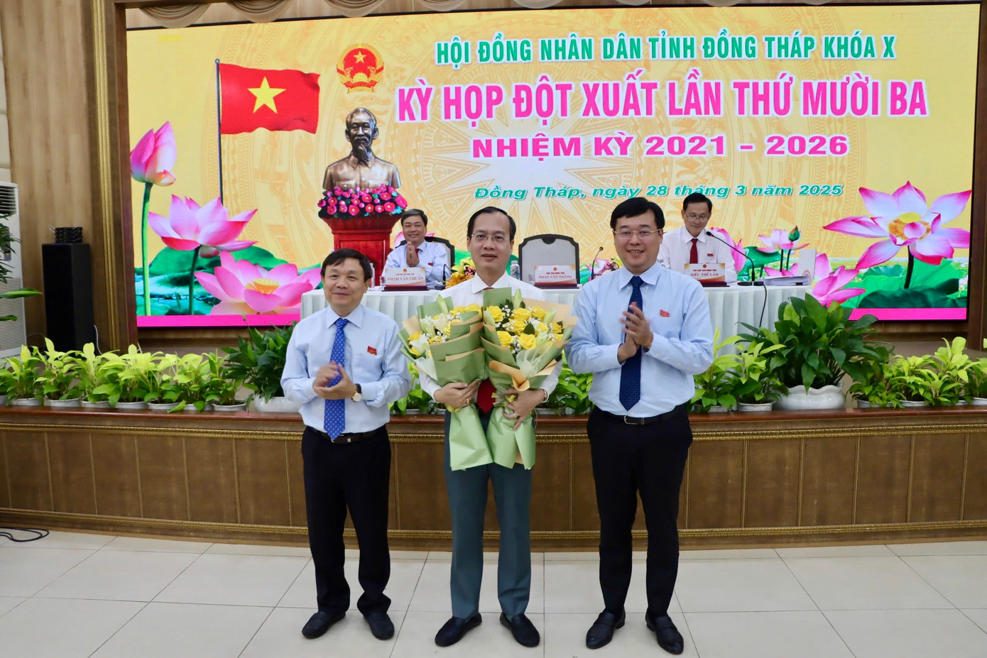 Ông Trần Trí Quang - tân Chủ tịch UBND tỉnh Đồng Tháp (giữa) nhận hoa chúc mừng từ Thường trực Tỉnh ủy.