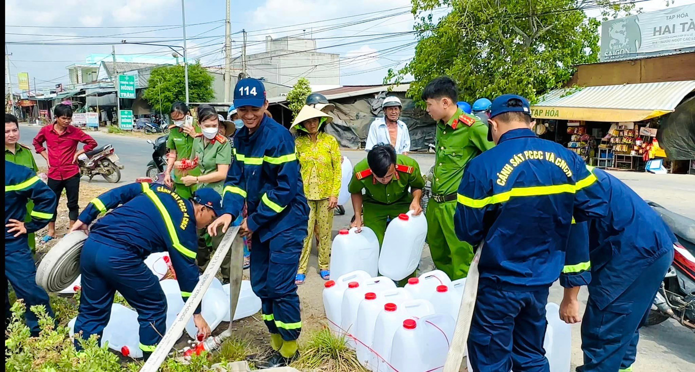 Công an tỉnh Bến Tre hỗ trợ nước sạch cho người dân vùng hạn mặn huyện Bình Đại. Chiến sĩ công an giúp dân buộc chặt can nước vào xe đạp. Chiến sĩ công an Bến Tre bơm nước sạch vào can giúp người dân.