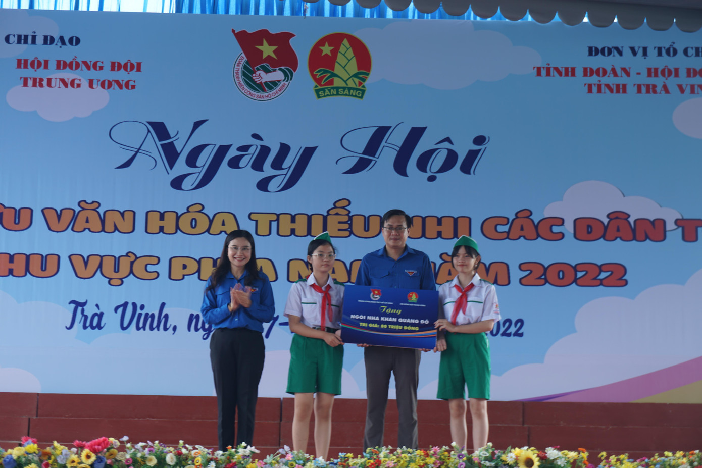 Chị Nguyễn Phạm Duy Trang, Bí Thư Trung ương Đoàn, Chủ tịch Hội đồng Đội Trung ương trao bảng tượng trưng tặng nhà khăn quàng đỏ cho thiếu nhi Trà Vinh. - Ảnh: TĐ TV Chị Nguyễn Phạm Duy Trang, Bí Thư Trung ương Đoàn, Chủ tịch Hội đồng Đội Trung ương trao bảng tượng trưng tặng nhà khăn quàng đỏ cho thiếu nhi Trà Vinh. - Ảnh: TĐ TV