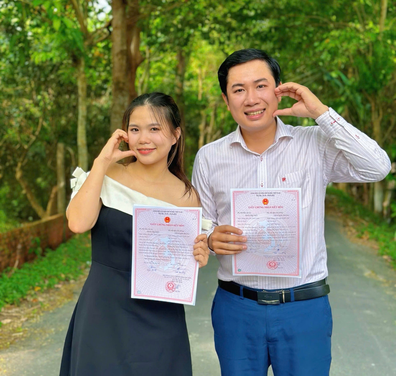 Hai người cầm trên tay giấy đăng ký kết hôn.