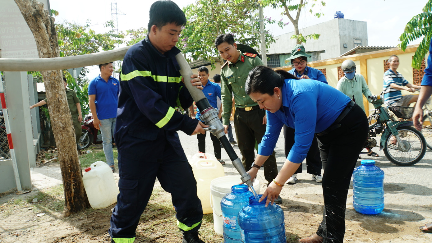 Chị Lâm Như Quỳnh - Bí thư Tỉnh Đoàn Bến Tre cùng ĐVTN, cán bộ hỗ trợ nước ngọt cho bà con sinh hoạt mùa hạn mặn. Ảnh: Hòa Hội