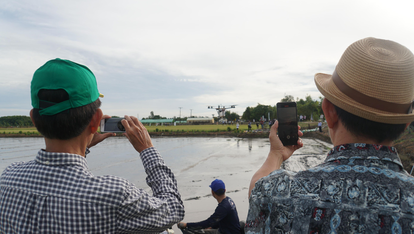 Người dân quay clip cảnh máy bay không người lái vận hành. Ảnh: Hòa Hội