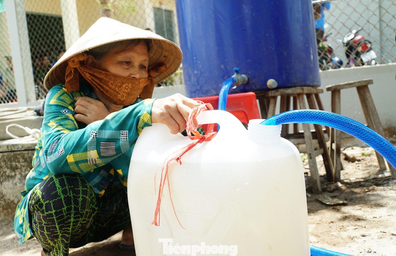 Người dân miền Tây hứng từng can nước về nhà sinh hoạt. Ảnh: Hòa Hội