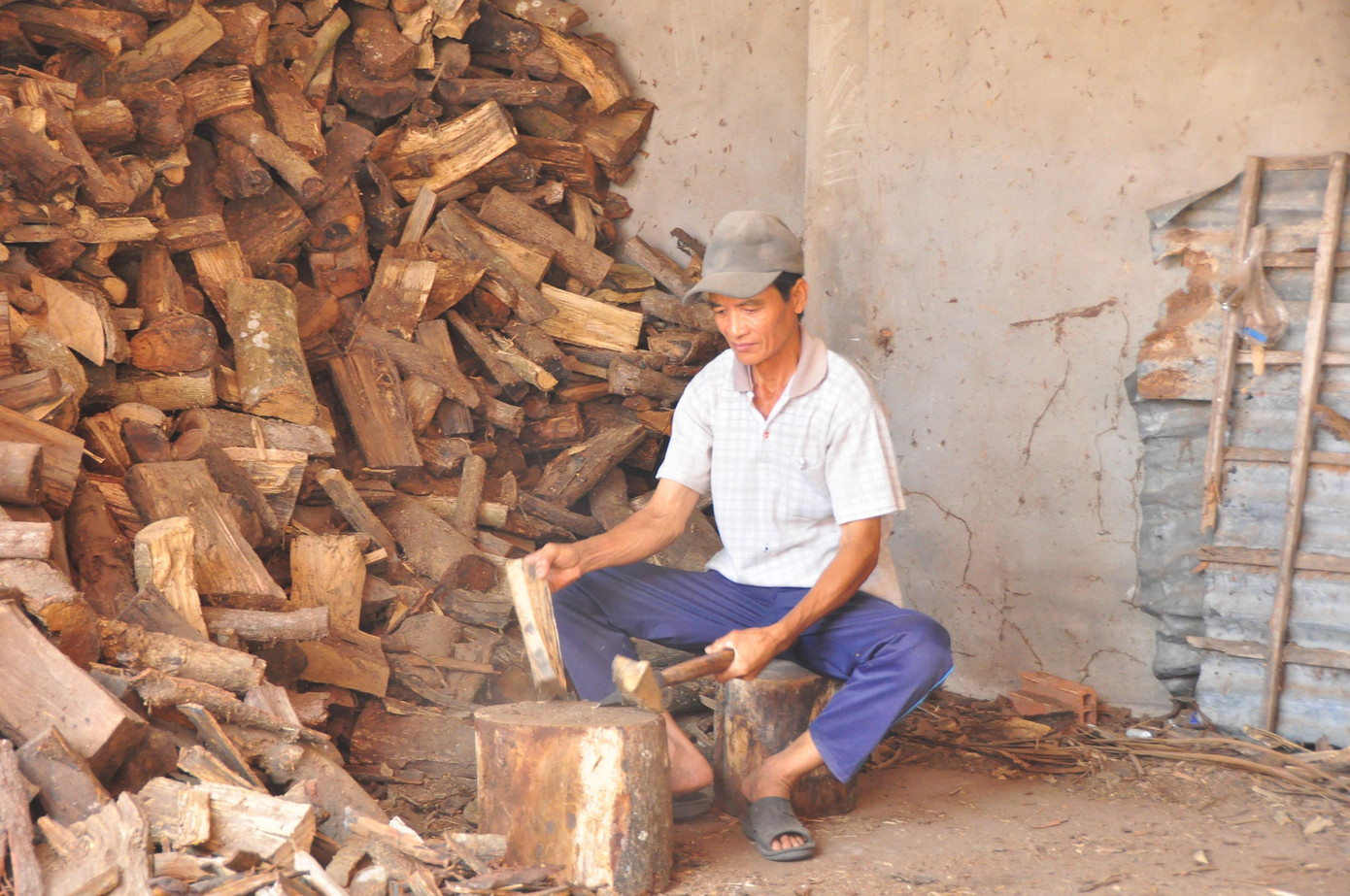 Người dân tình nguyện chẻ củi phụ giúp thiền viện duy trì lò lửa đúc bánh xèo.