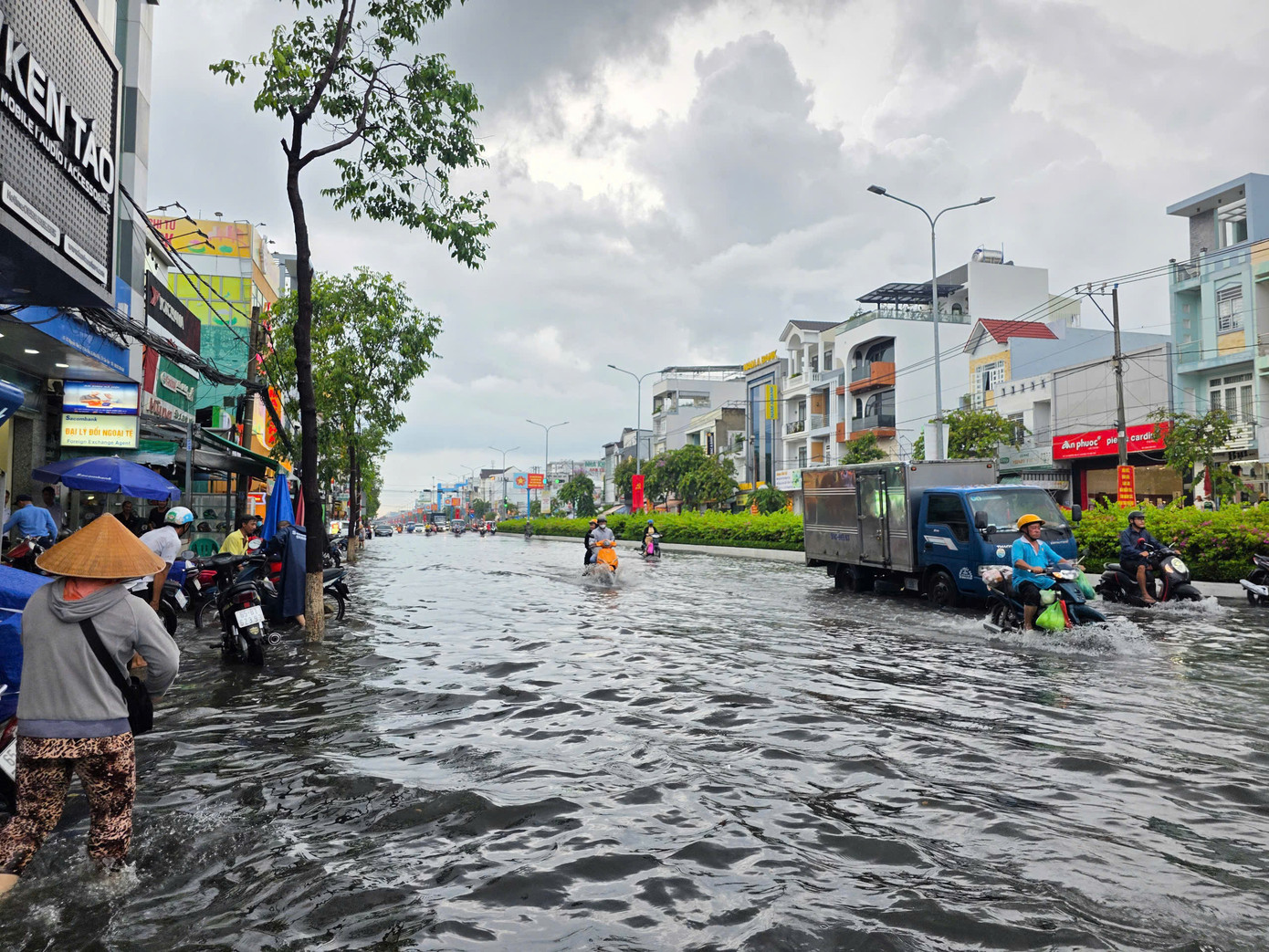 Người dân bì bõm trong nước sau cơn mưa to. Ảnh: M. Trung.
