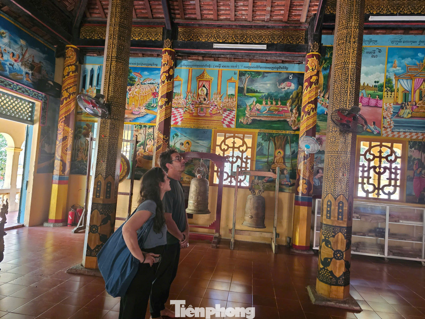 Trên bốn vách tường chính điện trang trí nhiều bức bích họa xoay quanh cuộc đời Đức Phật. Trên trần trang trí 4 bức tranh lớn gồm Phật đản sanh, Phật xuất gia, Phật đắc đạo và Phật niết bàn, do nghệ nhân Thạch Chan vẽ năm 1940. Trong ảnh, du khách quốc tế tham quan chánh điện. Ảnh: Hòa Hội.