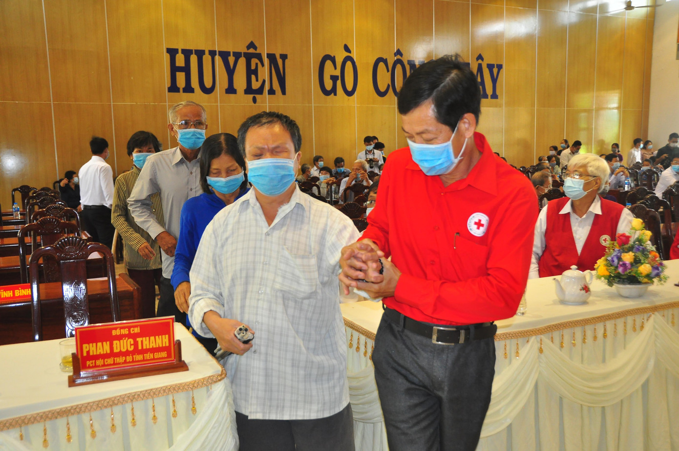 Cán bộ Hội chữ thập đỏ hỗ trợ người khuyết tật lên nhận quà Cán bộ Hội chữ thập đỏ hỗ trợ người khuyết tật lên nhận quà