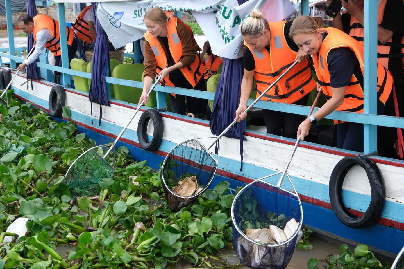 Các đại biểu tham gia vớt rác trên sông ở Cần Thơ nhằm giảm ô nhiễm môi trường.