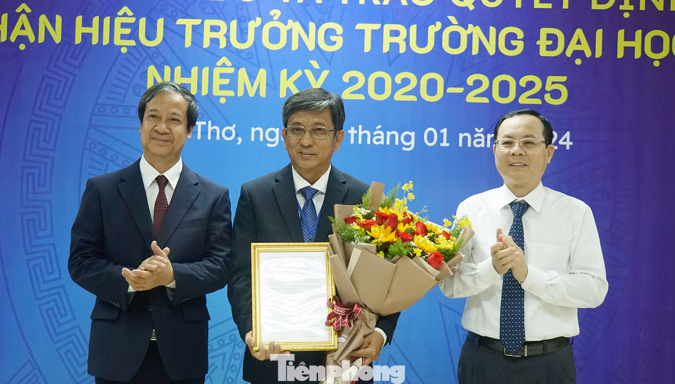 Bộ trưởng Bộ GD&amp;ĐT Nguyễn Kim Sơn (trái) cùng Bí thư Thành ủy Cần Thơ Nguyễn Văn Hiếu trao quyết định và tặng hoa chúc mừng PGS.TS Trần Trung Tính - Hiệu trưởng Trường Đại học Cần Thơ. Ảnh: Hòa Hội.