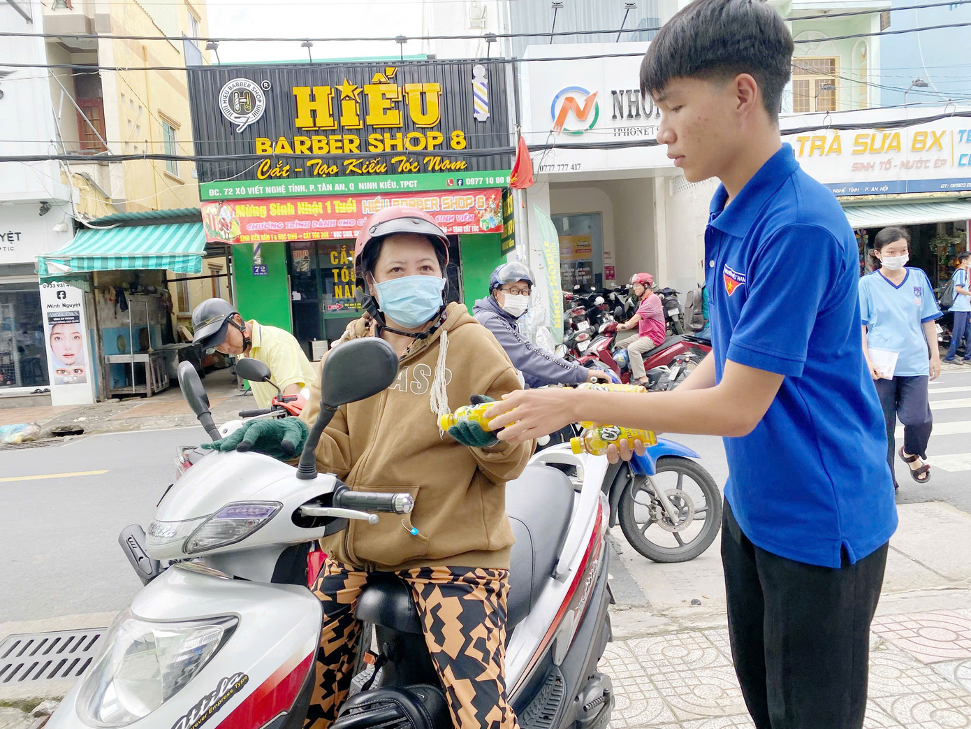 Phan Nguyễn Hoàng Minh tham gia tiếp sức mùa thi. Trong ảnh, Minh hỗ trợ nước cho phụ huynh đưa con đến điểm thi.