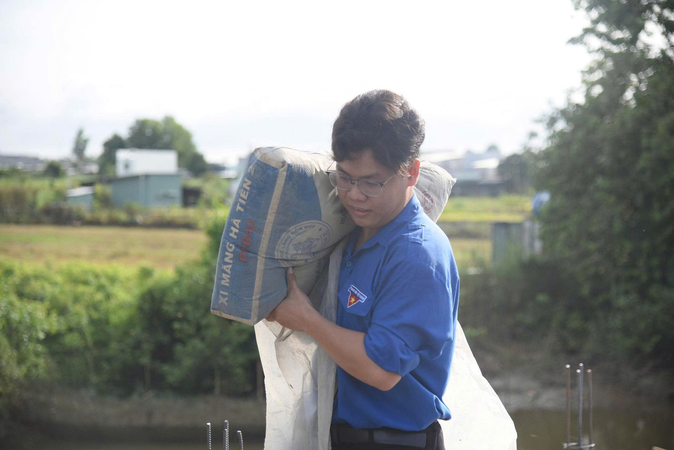 Sinh viên tình nguyện khuân xi măng làm cầu nông thôn.