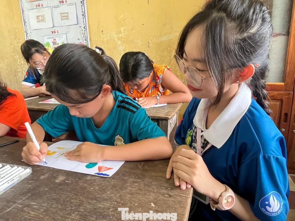 Tình nguyện viên hướng dẫn các em học bài.