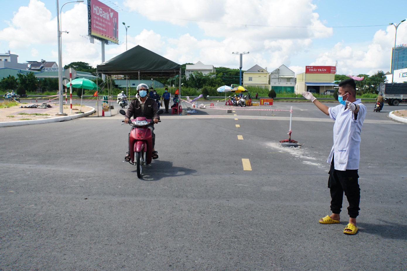 Tình nguyện viên làm việc giữa trưa nắng gay gắt. - Ảnh: Hòa Hội